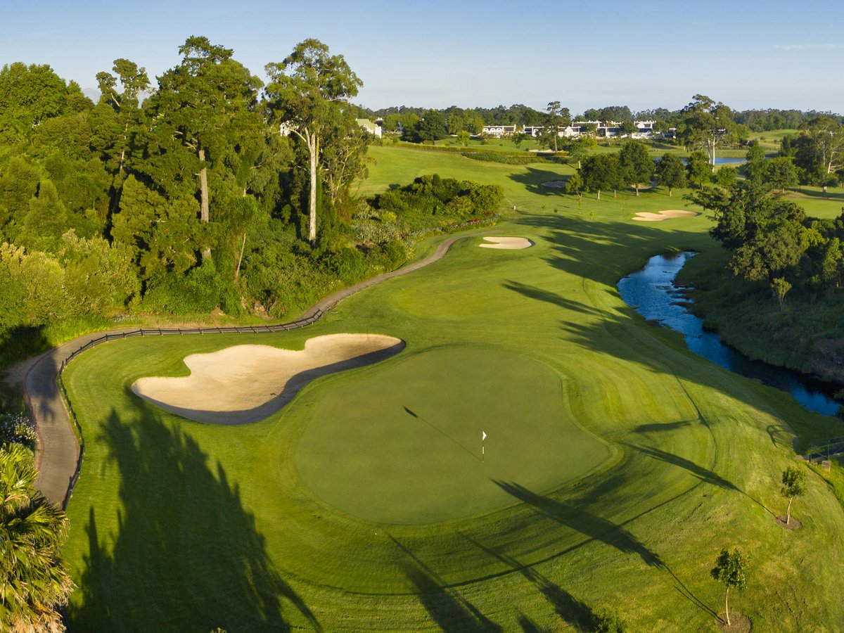 Idyllisch angelegter Golfkurs mit Bach und Bäumen