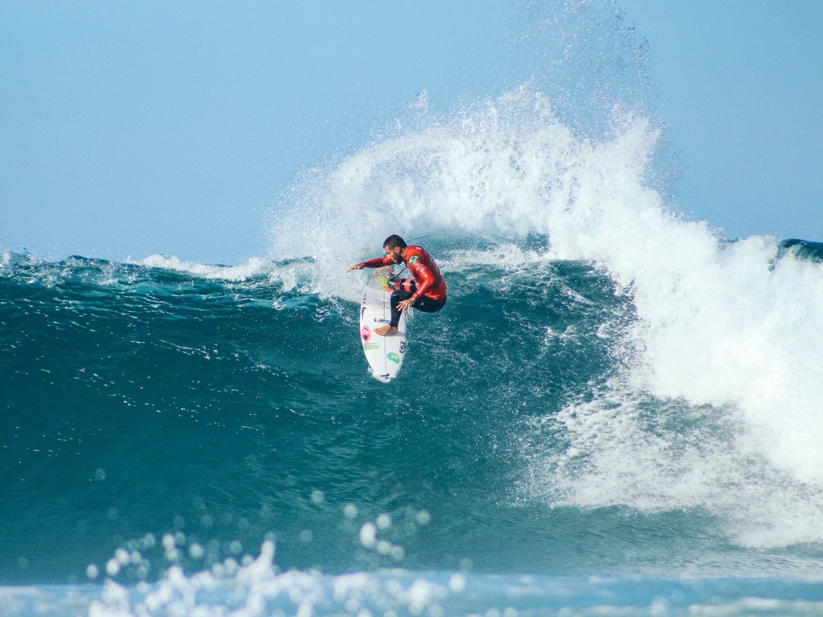 Sportlicher Surfer auf hoher Welle