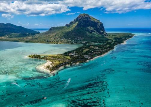 Luftaufnahme eines sehr markanten Felsens im Meer mit Landzunge