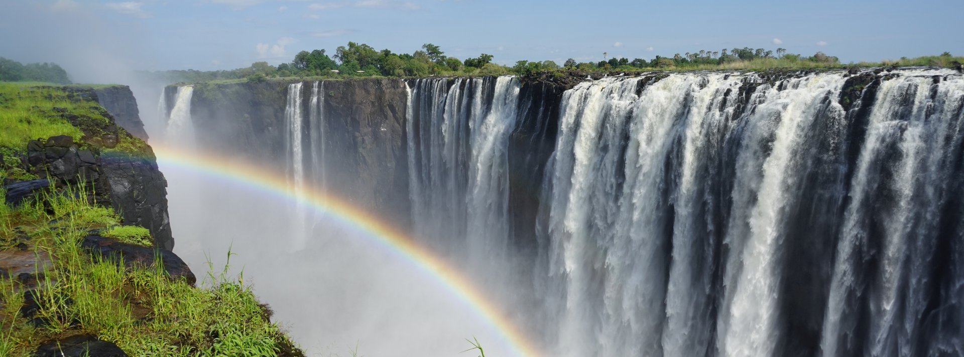 Regenbogen in einer Schlucht vor gewaltigem Wasserfall